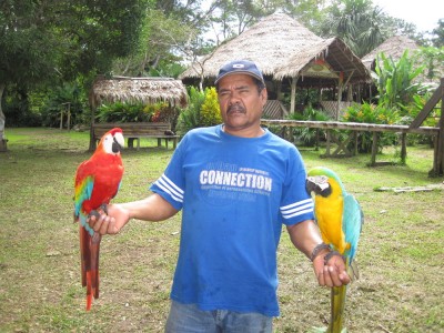 Mann mit zwei Ara am Ufer des Amazonas in Kolumbien bei Leticia
