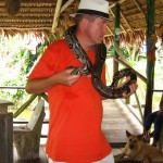 Tourist mit kleinen Anaconda auf den Schultern am Amazonas Kolumbiens bei Leticia